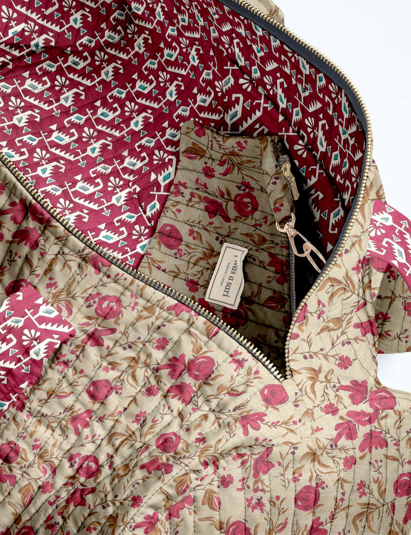 Brown paisley quilted bowling bag with dual handles, front zipper pocket, and "I was a sari" label on front side