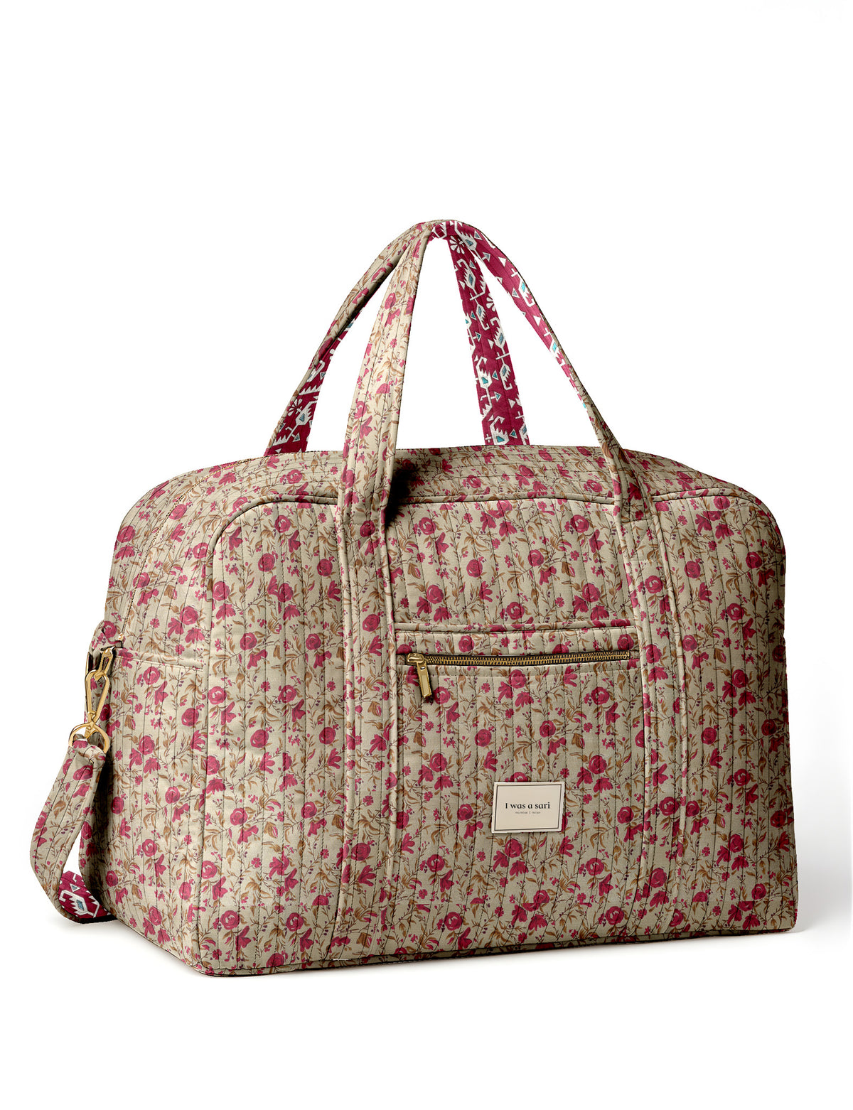 Brown quilted duffle bag with paisley pattern, front zip pocket, dual handles, and label reading "I was a sari"