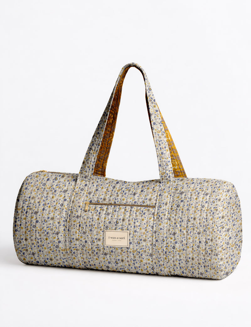 Brown paisley quilted bowling bag with dual handles, front zipper pocket, and "I was a sari" label on front side