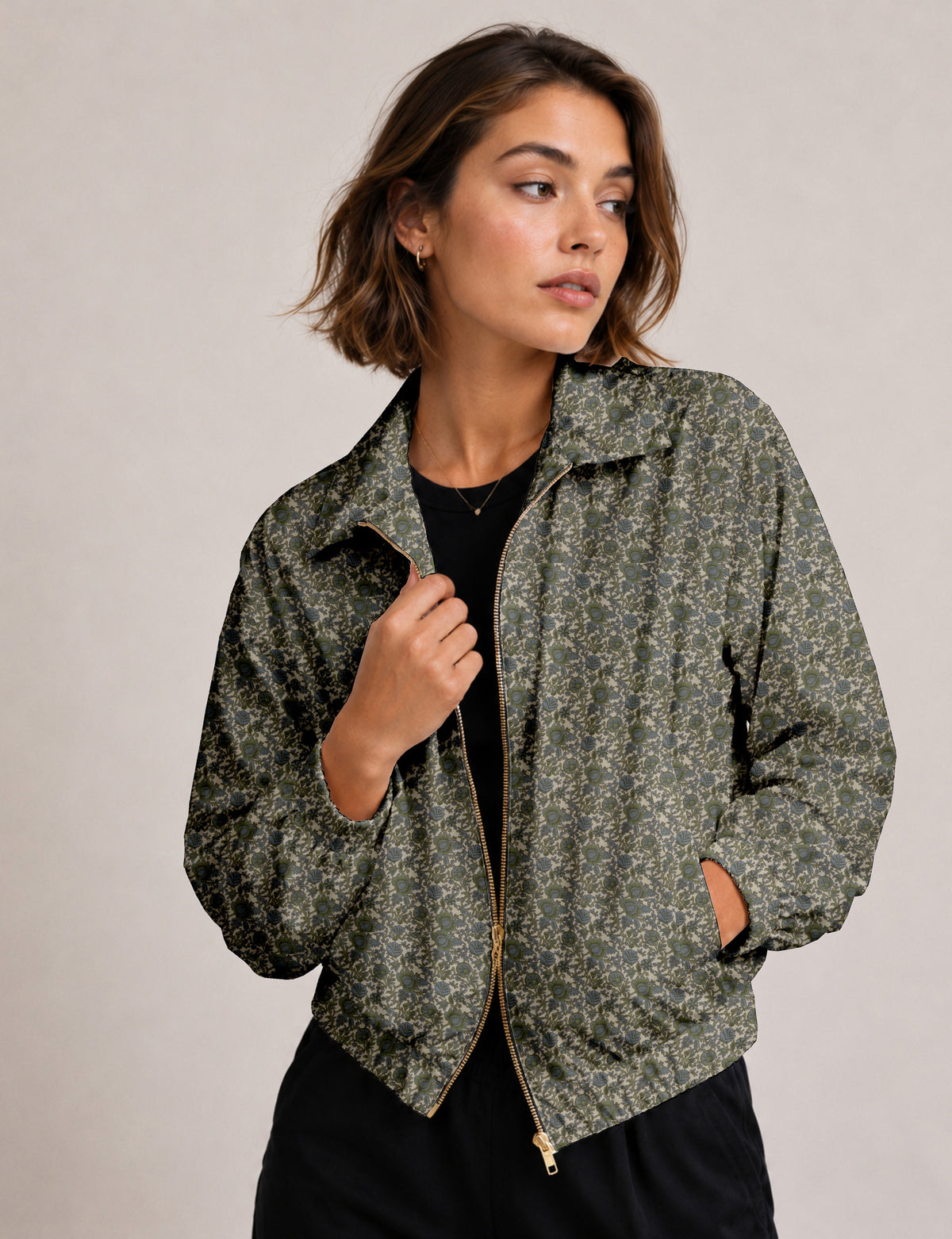 Woman wearing a yellow floral bomber jacket with front zipper, elastic cuffs, and side pockets, shown from front view