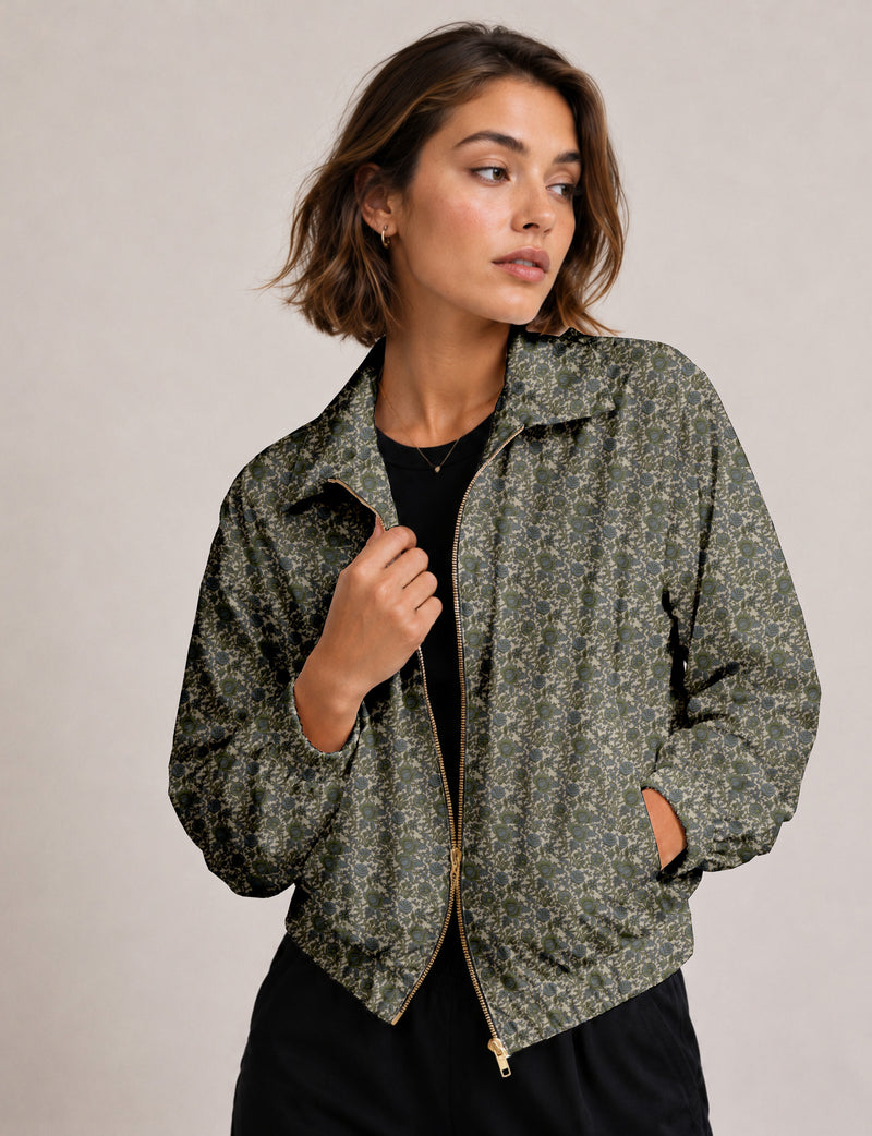 Woman wearing a yellow floral bomber jacket with front zipper, elastic cuffs, and side pockets, shown from front view