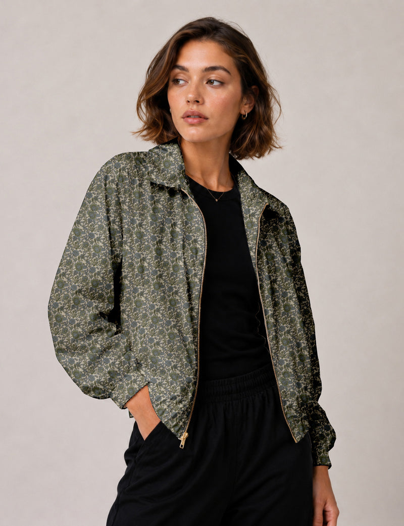 Brown floral bomber jacket with front zipper, elastic cuffs and hem, hanging on white hanger, red floral inner lining visible