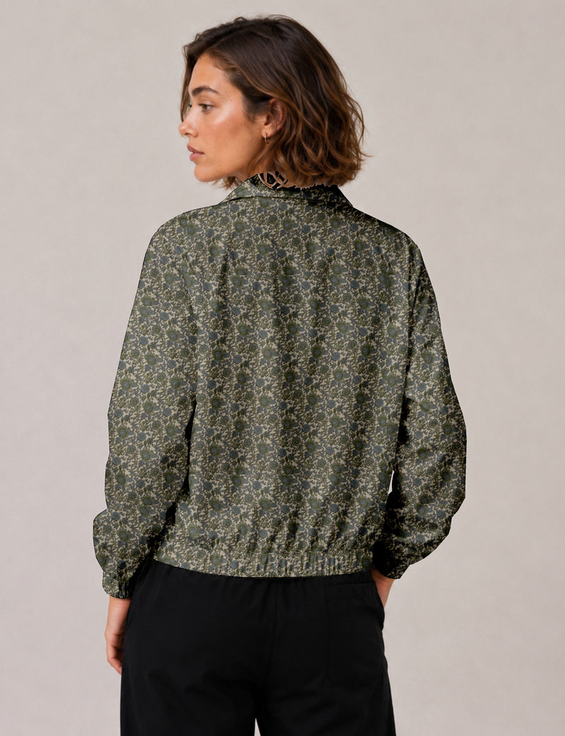 Woman wearing a yellow floral bomber jacket with front zipper, elastic cuffs, and side pockets, shown from front view