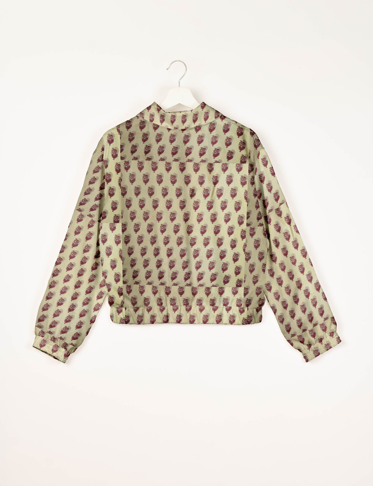 Beige bomber jacket with maroon leaf pattern, elastic cuffs, and back view on white hanger against white background