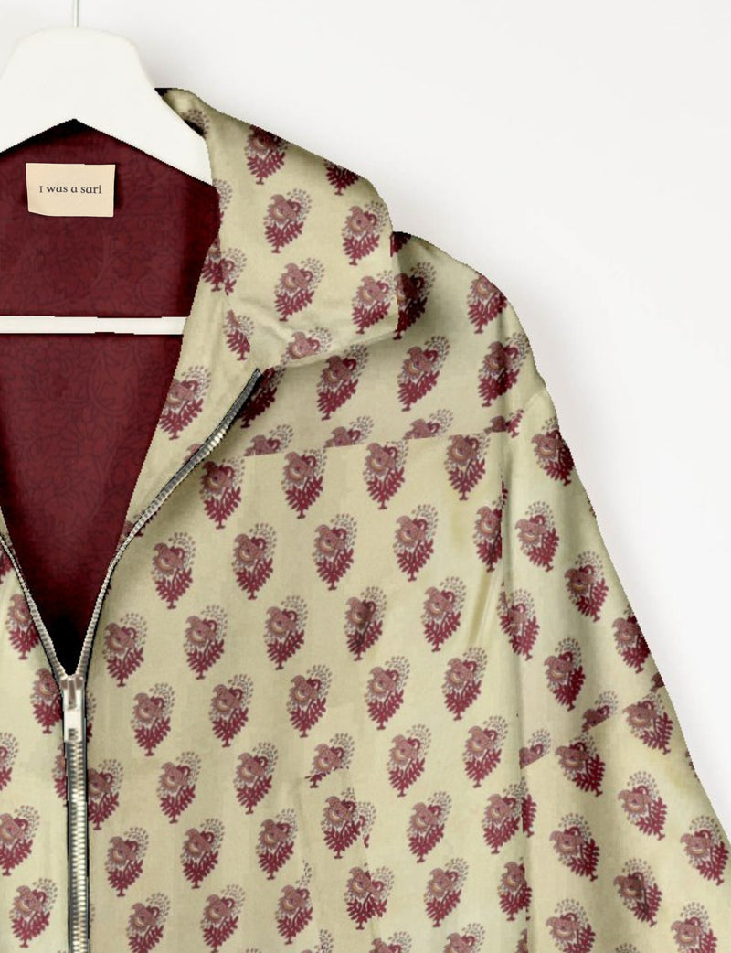 Beige bomber jacket with maroon leaf pattern, silver zipper, and maroon inner lining on white hanger with "I was a sari"