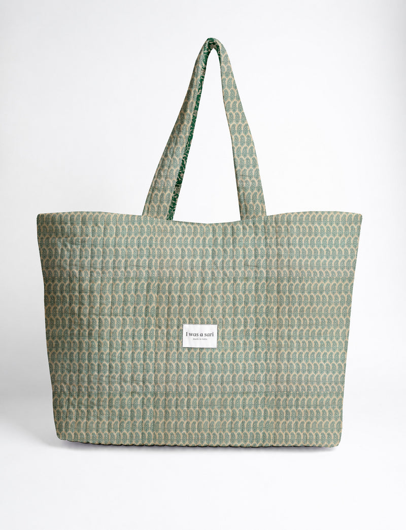 Quilted yellow tropical patterned beach bag with long handles and white label reading "I was a sari" front view