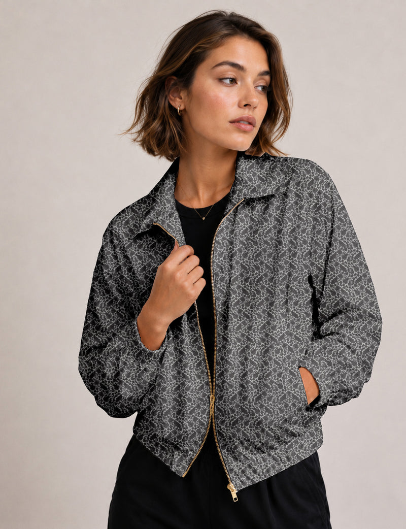 Woman wearing a yellow floral bomber jacket with front zipper, elastic cuffs, and side pockets, shown from front view