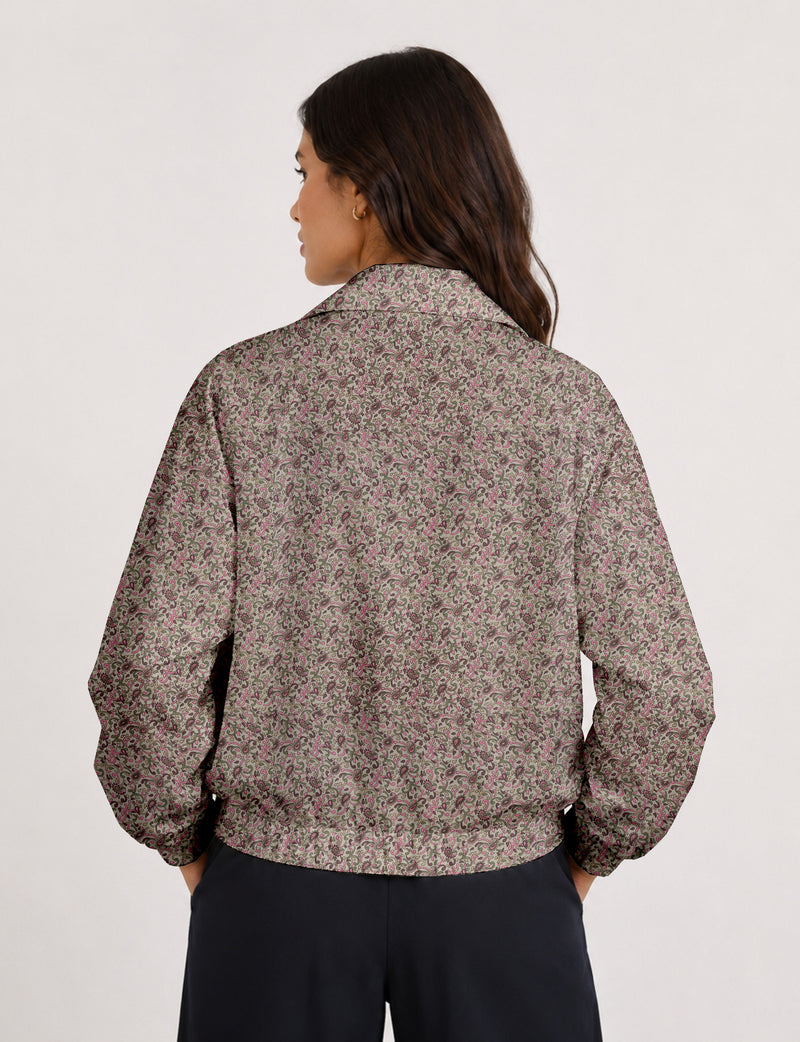 Brown floral bomber jacket with front zipper, elastic cuffs and hem, hanging on white hanger, red floral inner lining visible