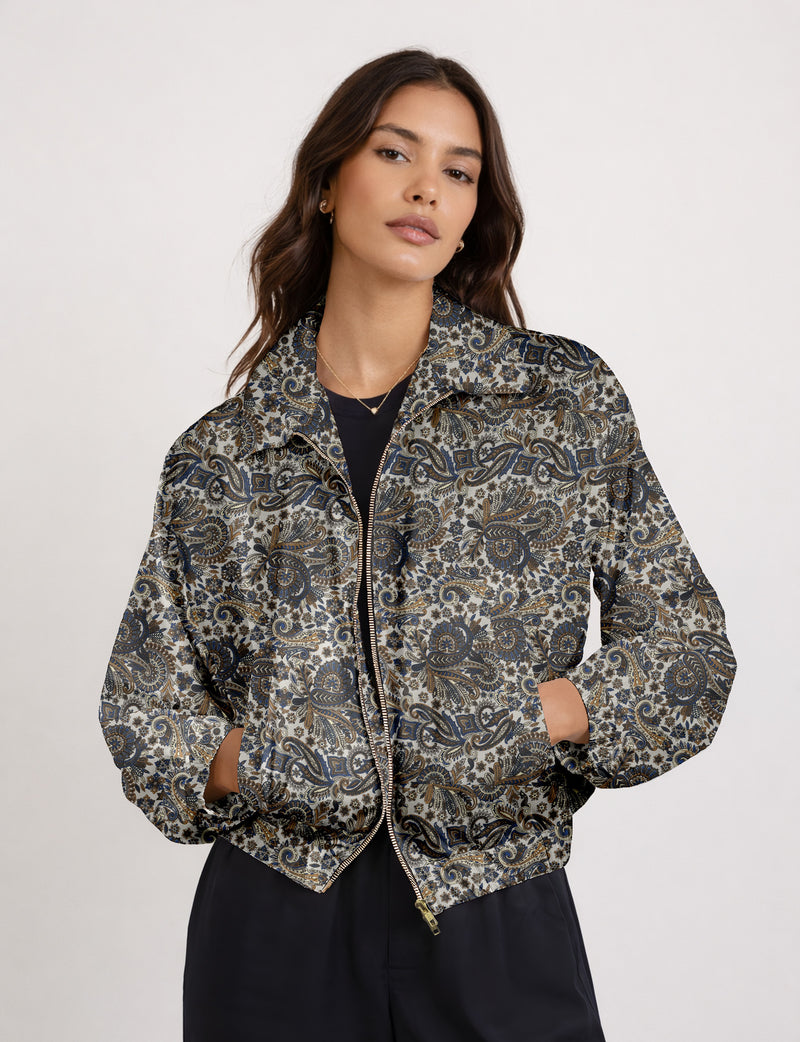 Woman wearing a yellow floral bomber jacket with front zipper, elastic cuffs, and side pockets, shown from front view