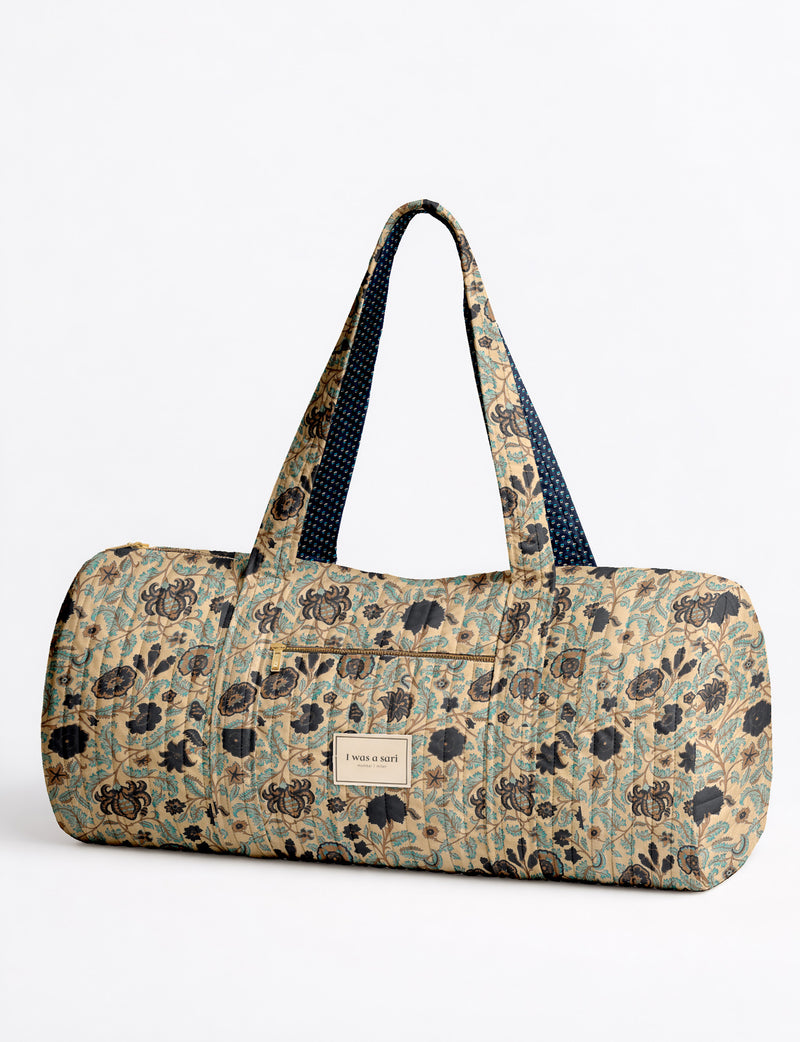 Brown paisley quilted bowling bag with dual handles, front zipper pocket, and "I was a sari" label on front side