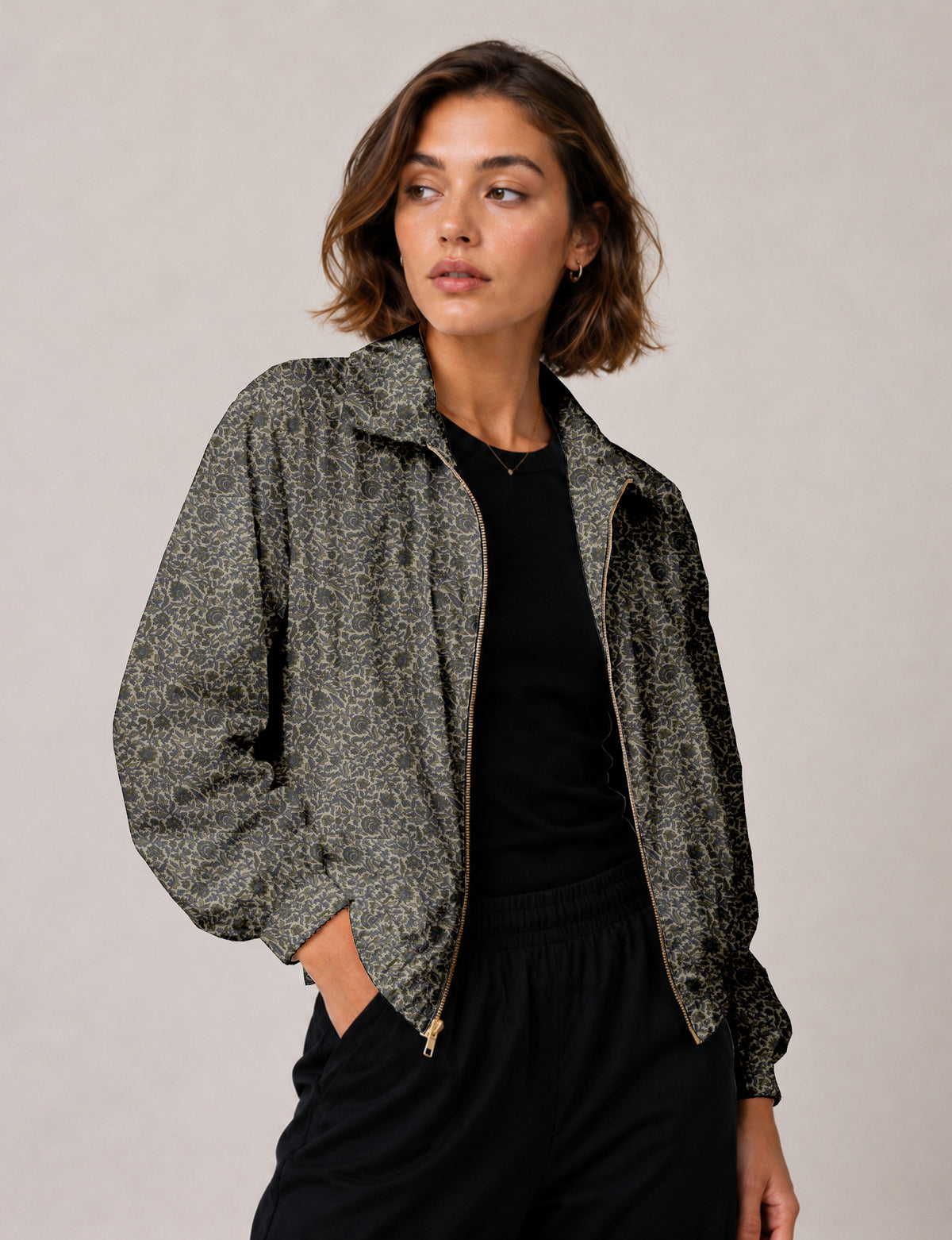 Woman wearing a yellow floral bomber jacket with front zipper, elastic cuffs, and side pockets, shown from front view