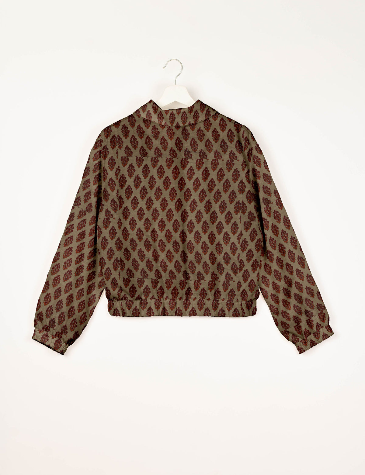 Beige bomber jacket with red tropical leaf pattern, long sleeves, elastic cuffs and waistband, shown from back on hanger
