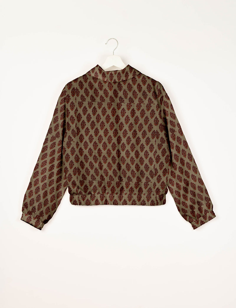 Beige bomber jacket with red tropical leaf pattern, long sleeves, elastic cuffs and waistband, shown from back on hanger