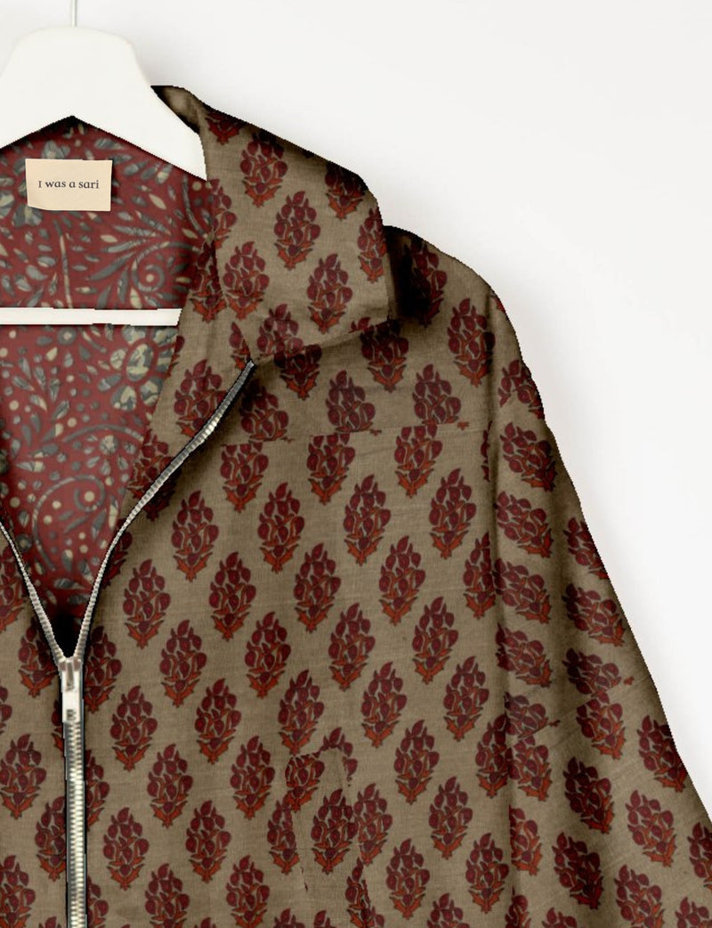 Beige bomber jacket with red floral tropical print, silver zipper, and red patterned inner lining on white hanger