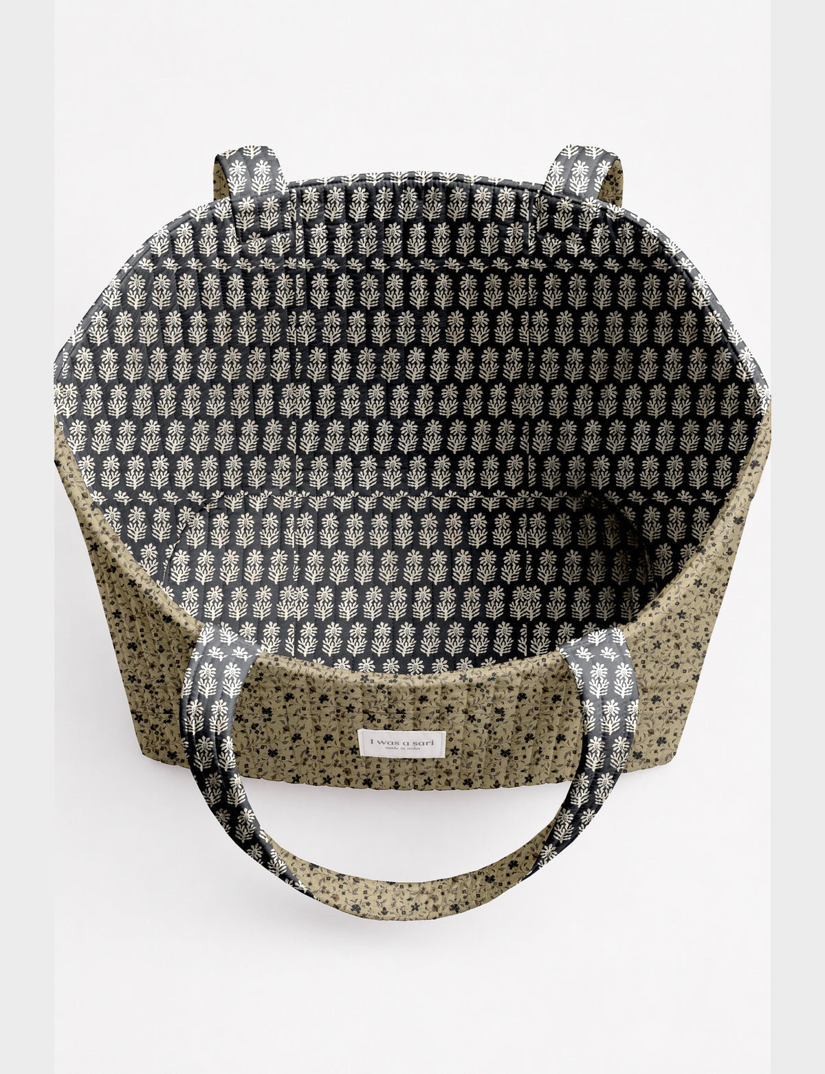 Quilted beach bag with yellow tropical exterior and red patterned interior, shown from top view with handles visible