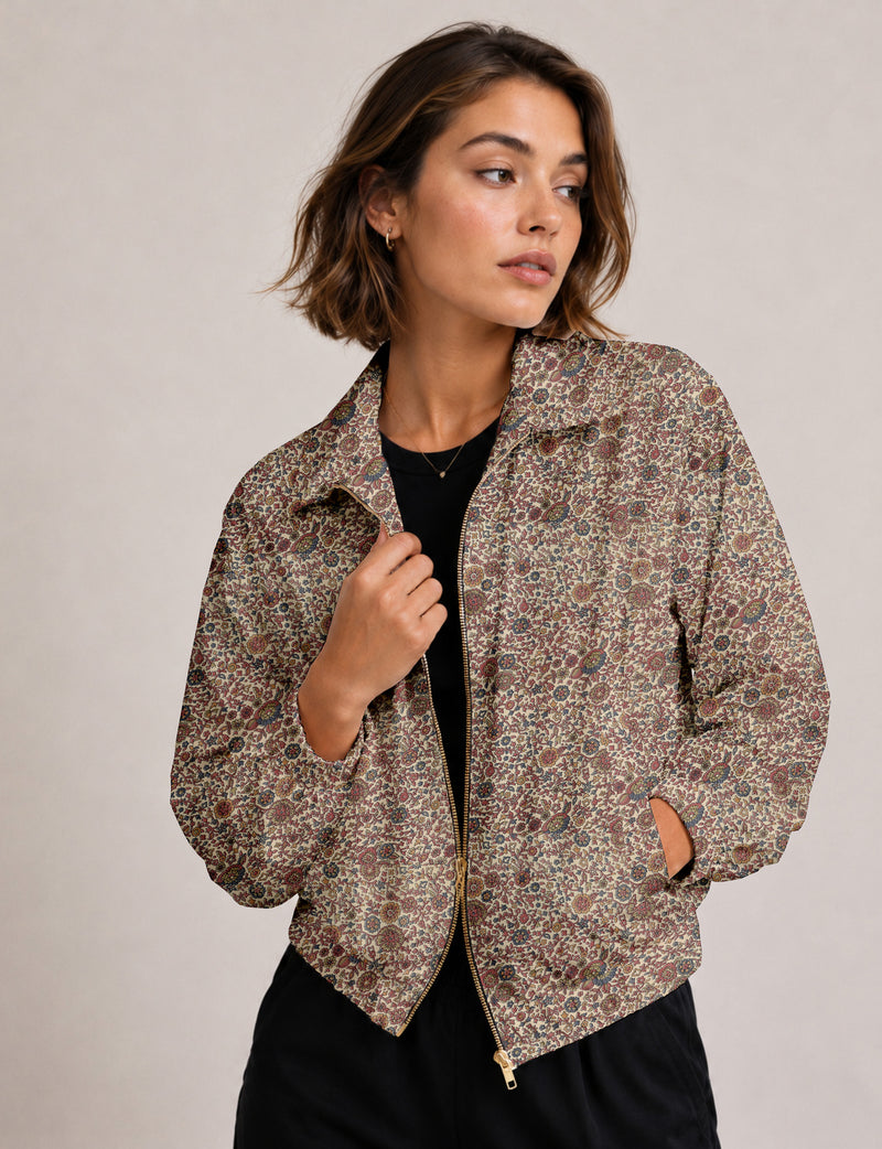 Woman wearing a yellow floral bomber jacket with front zipper, elastic cuffs, and side pockets, shown from front view