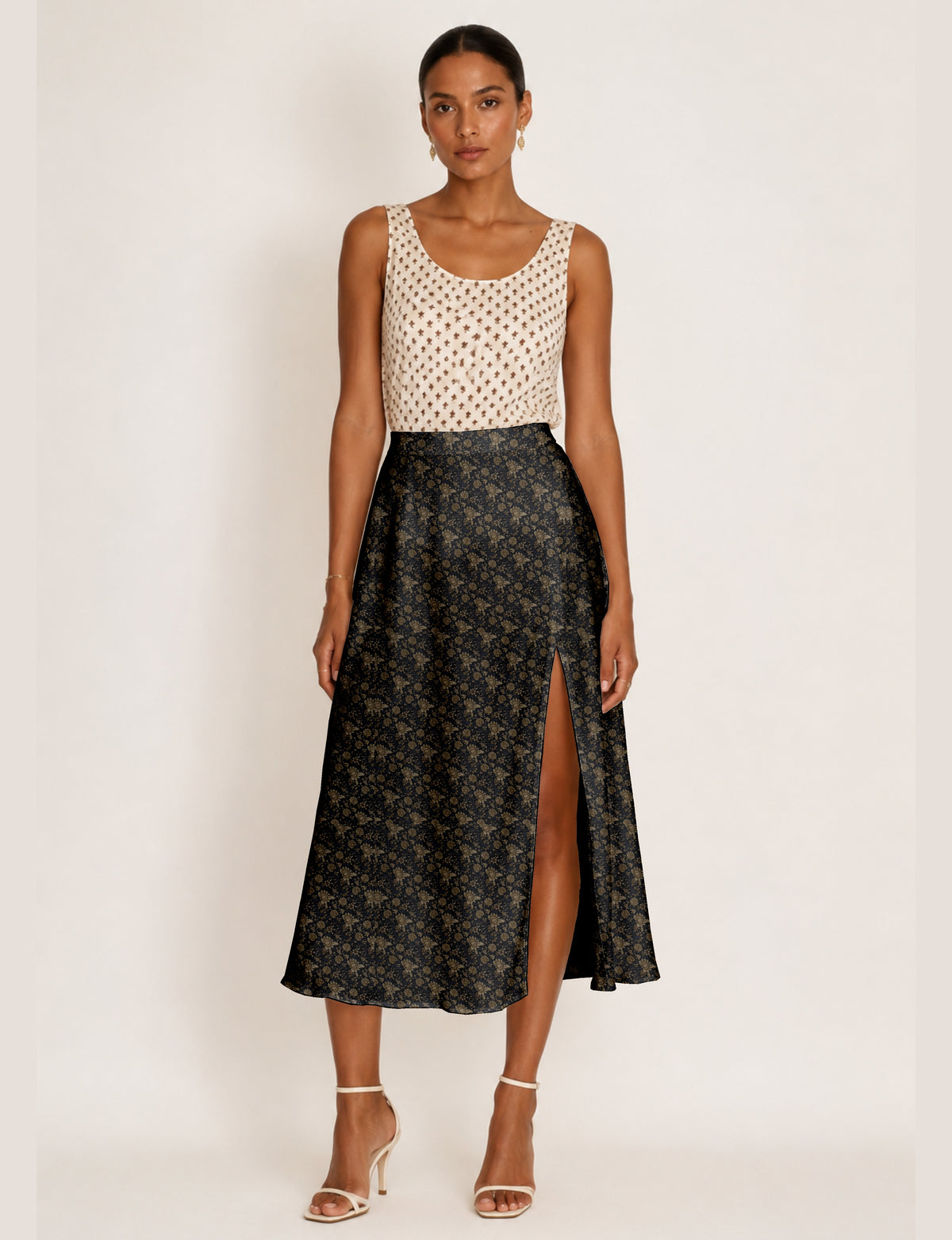 Woman wearing a yellow and black micro patterned A-line skirt with front slit, paired with beige sleeveless top and black
