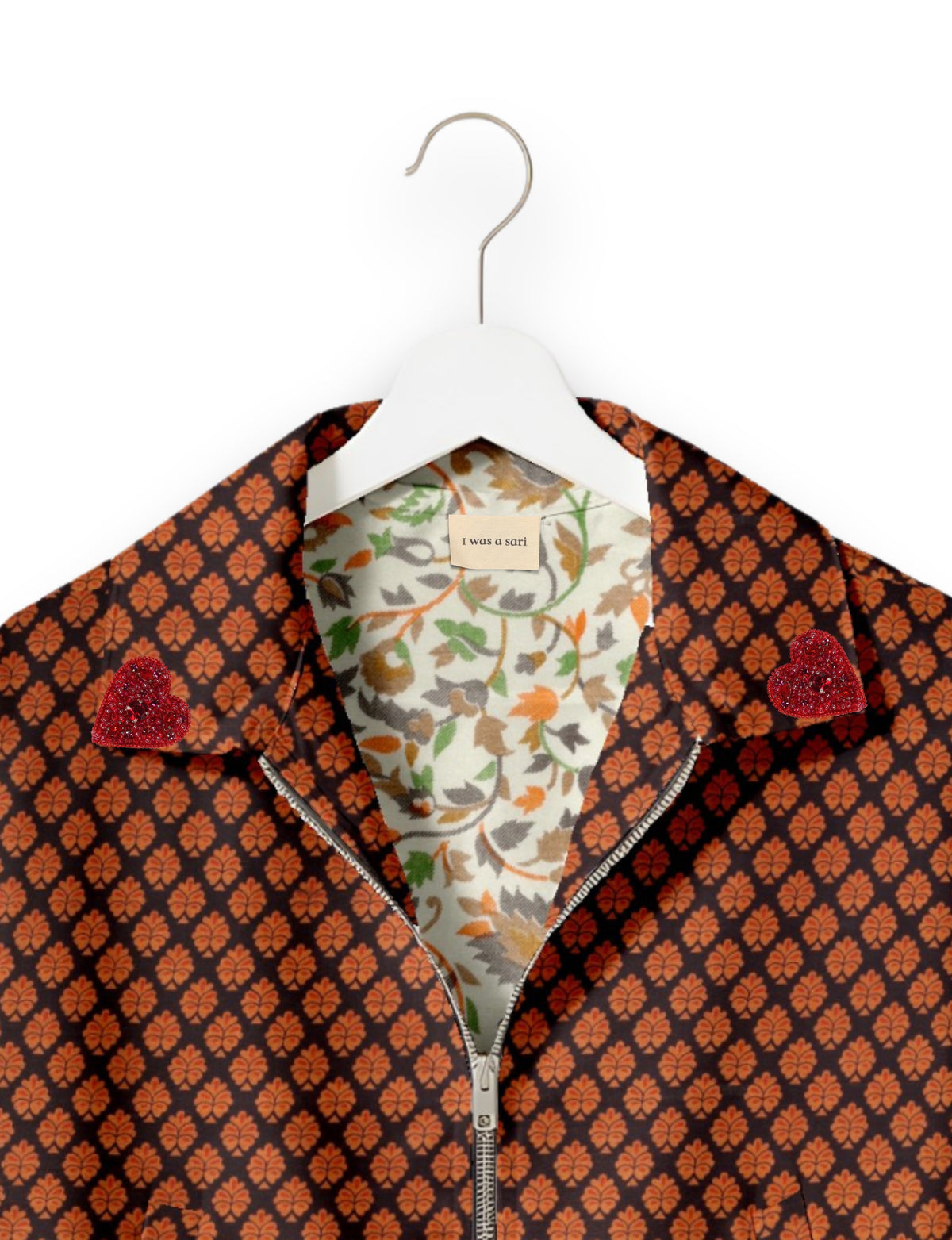 Black bomber jacket with orange leaf pattern, red heart embellishments on collar, floral inner lining, and front zipper, on