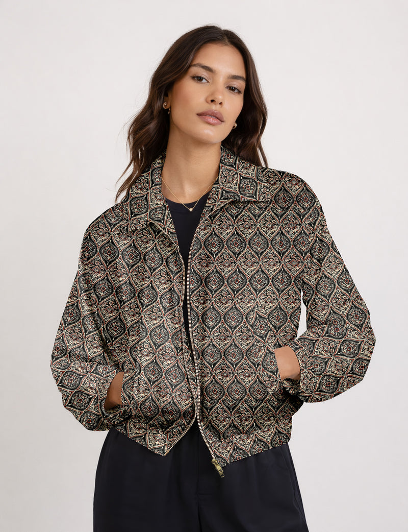 Woman wearing a yellow floral bomber jacket with front zipper, elastic cuffs, and side pockets, shown from front view