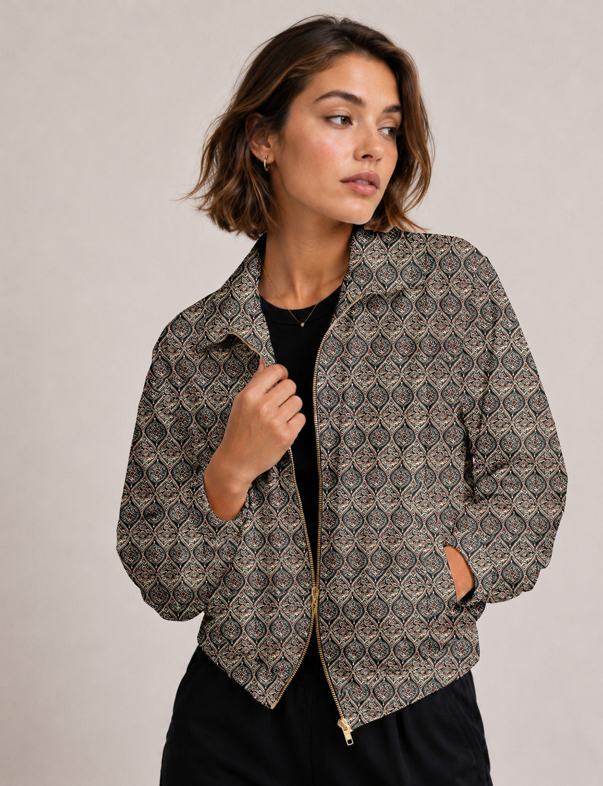 Brown floral bomber jacket with front zipper, elastic cuffs and hem, hanging on white hanger, red floral inner lining visible