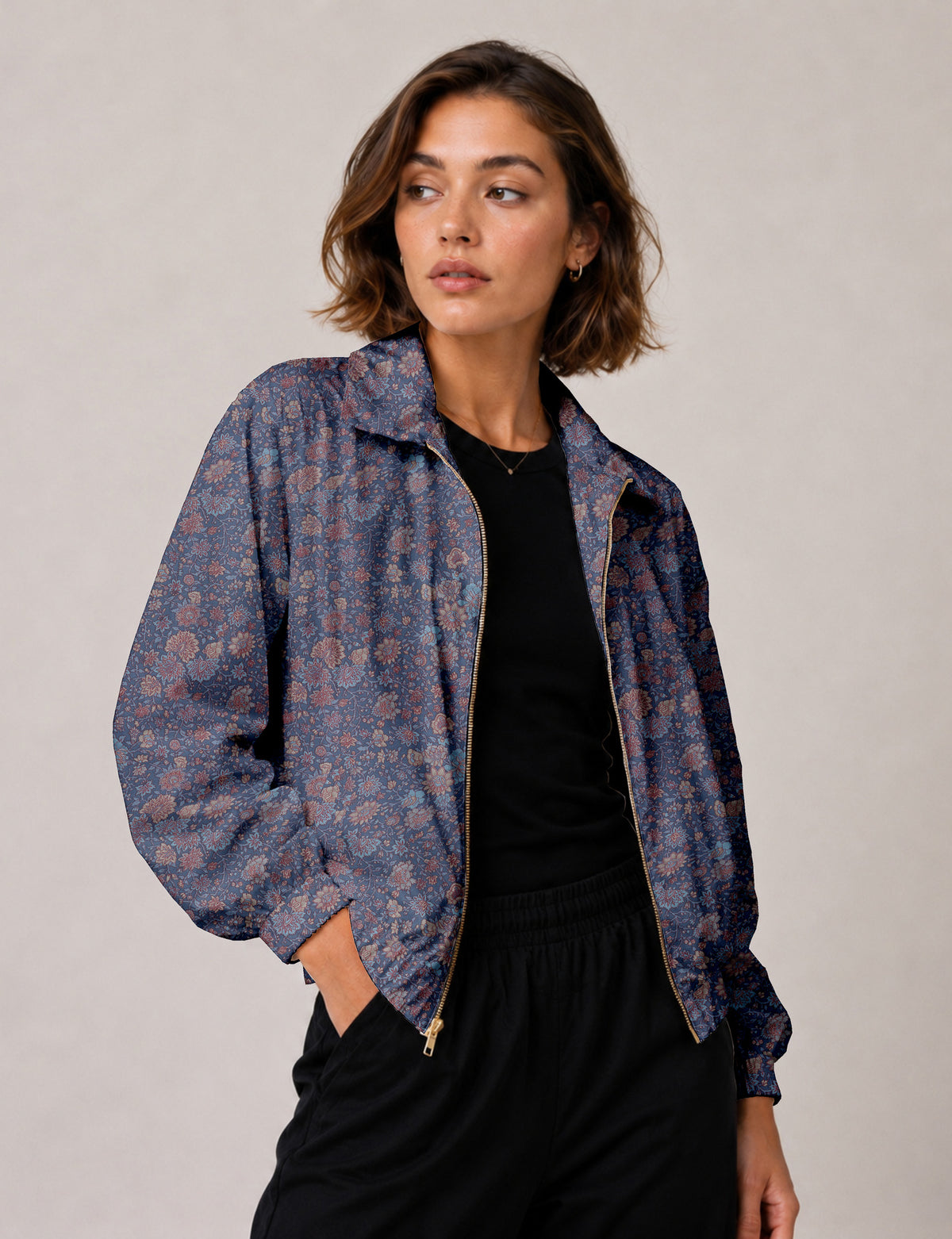 Woman wearing a yellow floral bomber jacket with front zipper, elastic cuffs, and side pockets, shown from front view