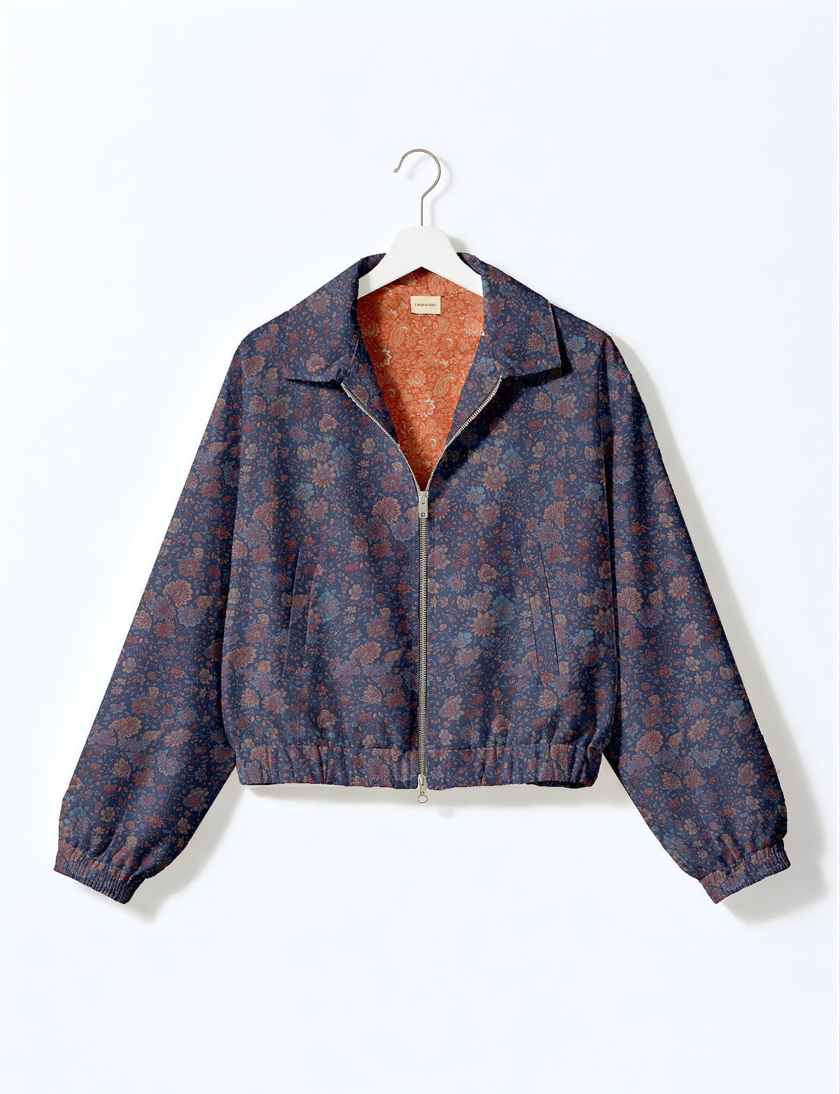 Brown floral bomber jacket with front zipper, elastic cuffs and hem, hanging on white hanger, red floral inner lining visible
