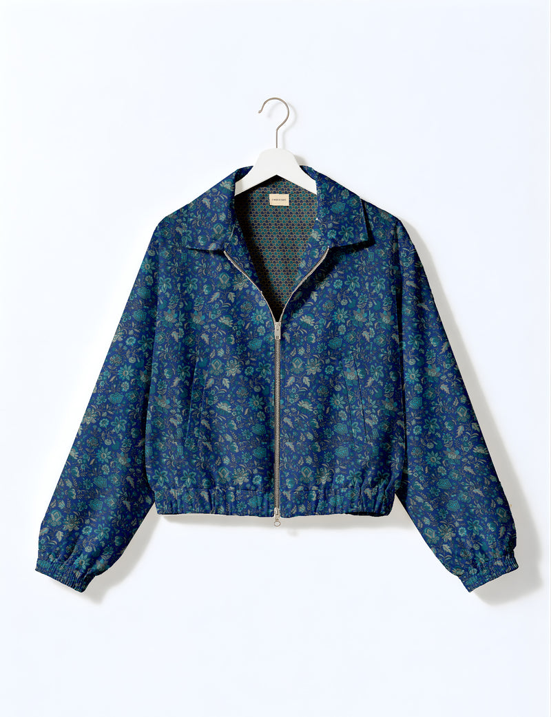 Brown floral bomber jacket with front zipper, elastic cuffs and hem, hanging on white hanger, red floral inner lining visible
