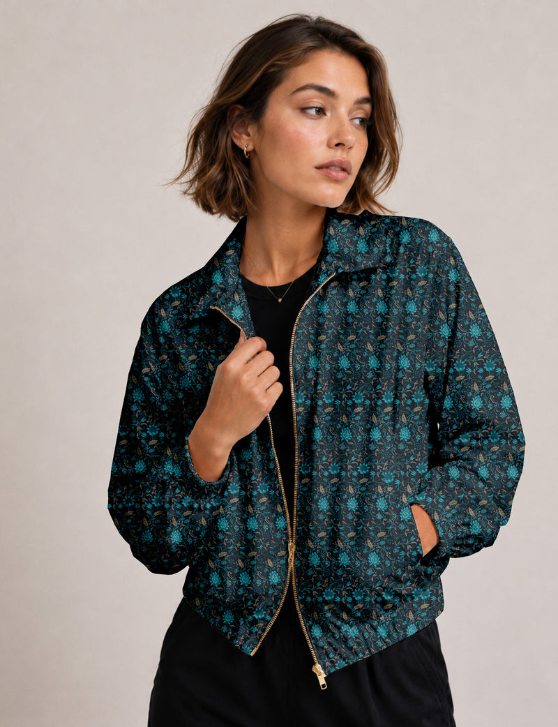 Woman wearing a yellow floral bomber jacket with front zipper, elastic cuffs, and side pockets, shown from front view