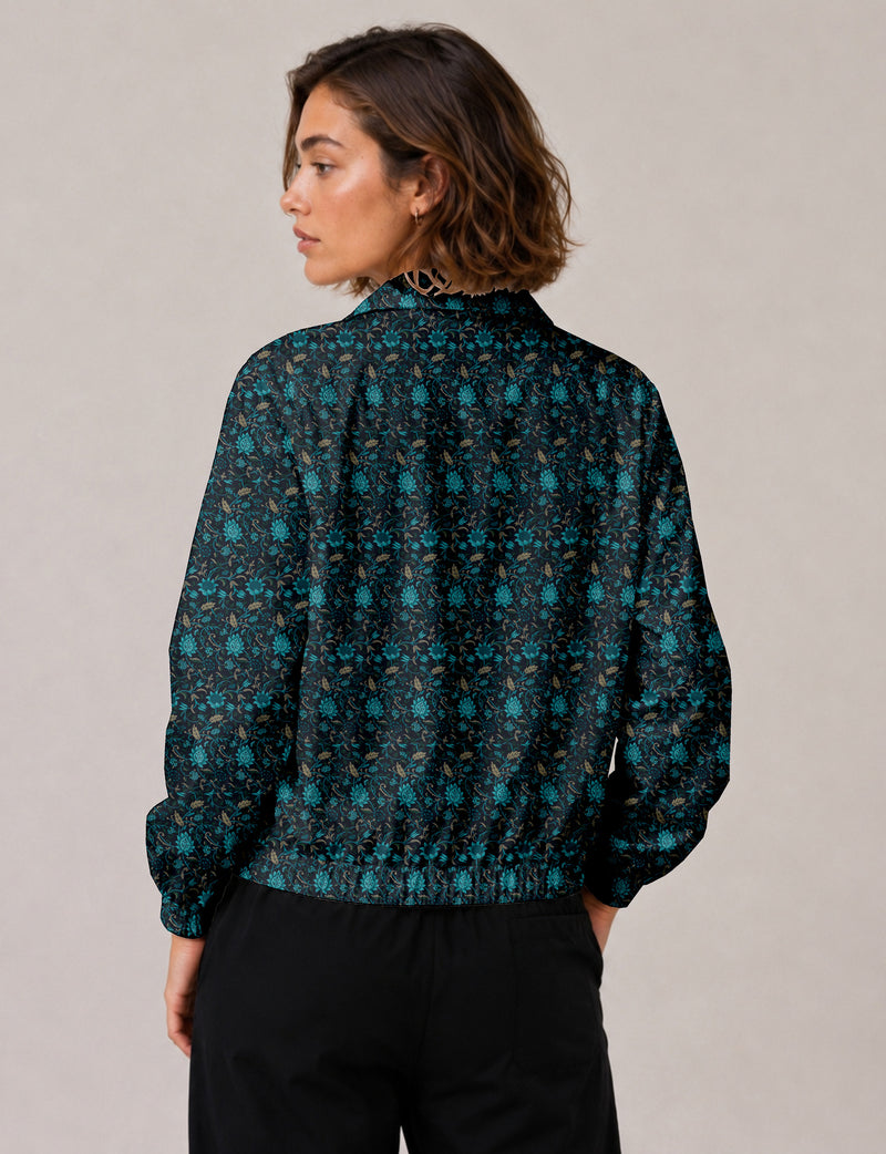 Woman wearing a yellow floral bomber jacket with front zipper, elastic cuffs, and side pockets, shown from front view