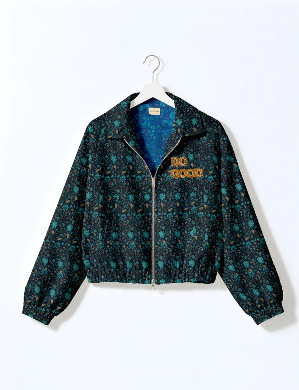 Gold cropped DO GOOD bomber jacket featuring hand-embroidered lettering on the left chest, contrasting inner lining and two functional pockets.