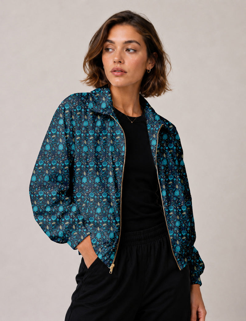 Woman wearing a yellow floral bomber jacket with front zipper, elastic cuffs, and side pockets, shown from front view
