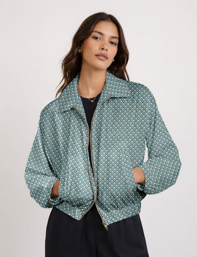 Woman wearing a yellow floral bomber jacket with front zipper, elastic cuffs, and side pockets, shown from front view