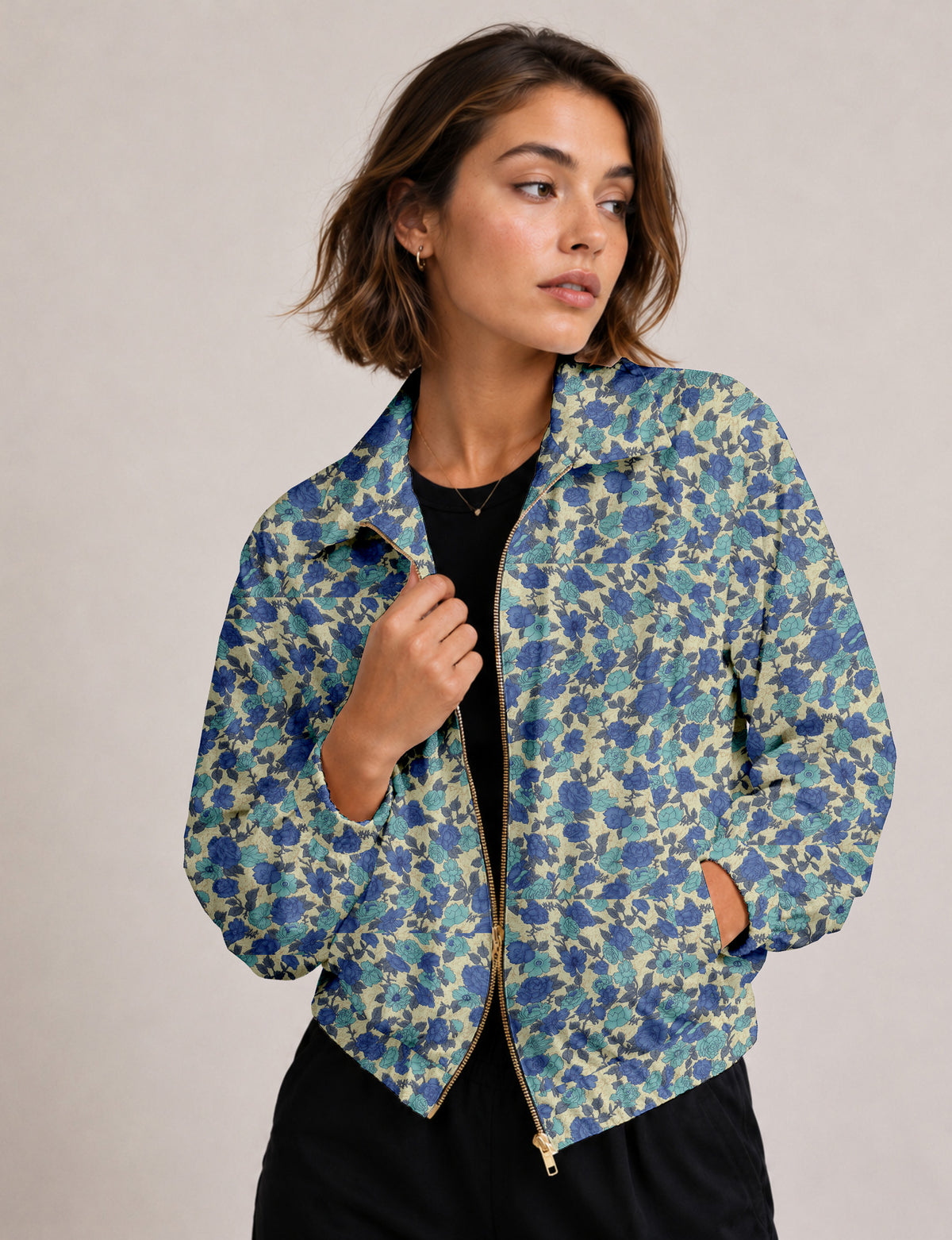 Brown floral bomber jacket with front zipper, elastic cuffs and hem, hanging on white hanger, red floral inner lining visible
