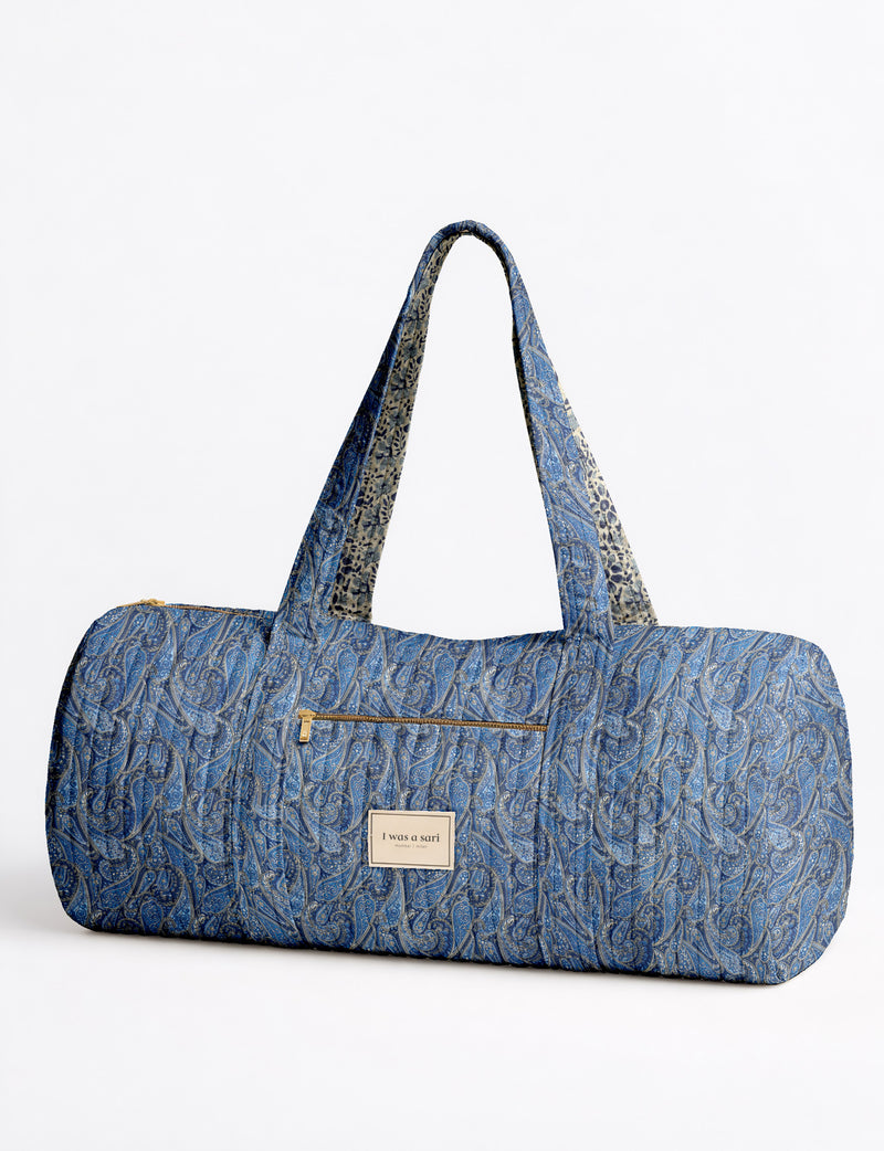 Brown paisley quilted bowling bag with dual handles, front zipper pocket, and "I was a sari" label on front side