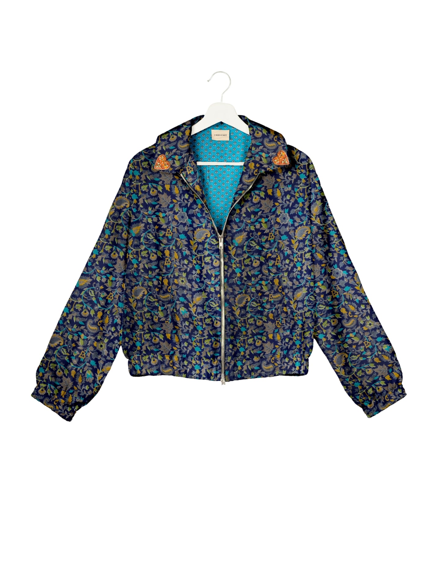 Make a bold statement with our Heart Drop Earrings, a symbol of conscious luxury and ethical fashion. Handcrafted using the intricate Aari embroidery technique, these earrings are made from upcycled sari fabric, embracing slow fashion and zero waste clothing. Elevate your look with sustainable apparel that supports fair trade fashion while reducing textile waste. Choose eco-friendly fashion that speaks of love, artistry, and responsibility.