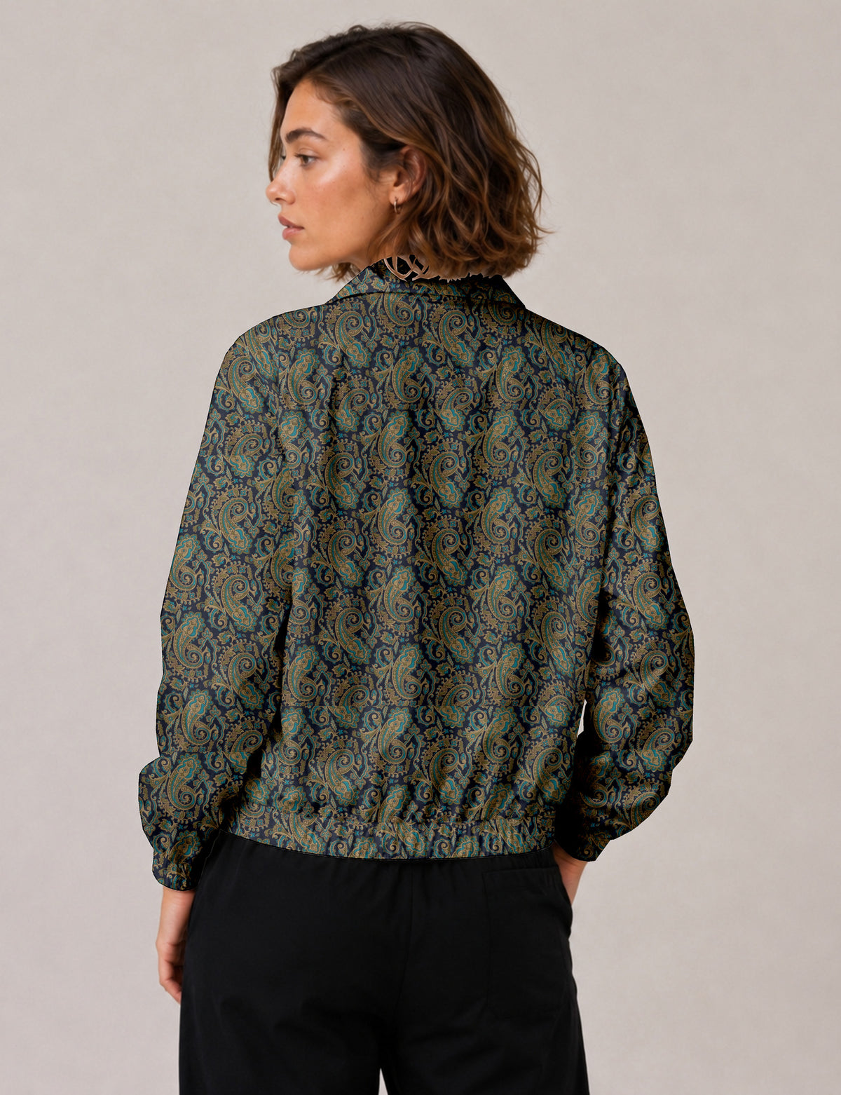 Woman wearing a yellow floral bomber jacket with front zipper, elastic cuffs, and side pockets, shown from front view
