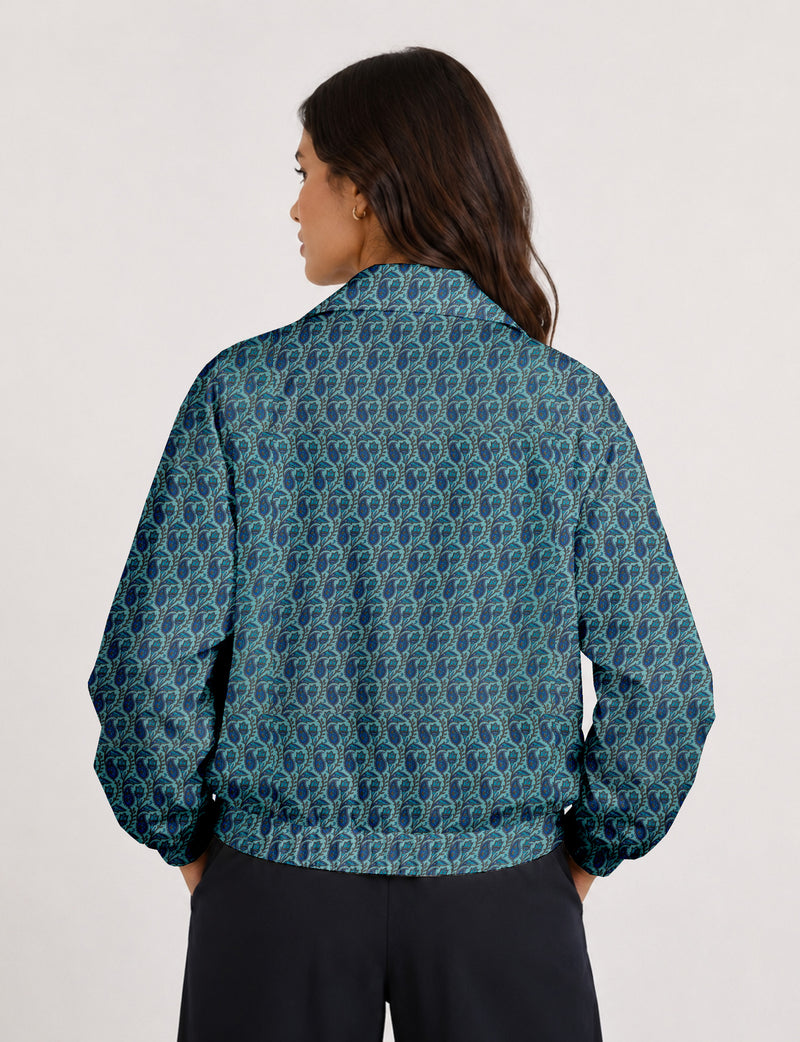 Woman wearing a yellow floral bomber jacket with front zipper, elastic cuffs, and side pockets, shown from front view