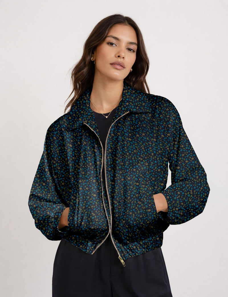 Brown floral bomber jacket with front zipper, elastic cuffs and hem, hanging on white hanger, red floral inner lining visible