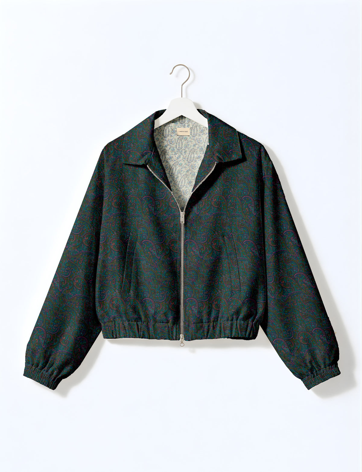 Brown floral bomber jacket with front zipper, elastic cuffs and hem, hanging on white hanger, red floral inner lining visible
