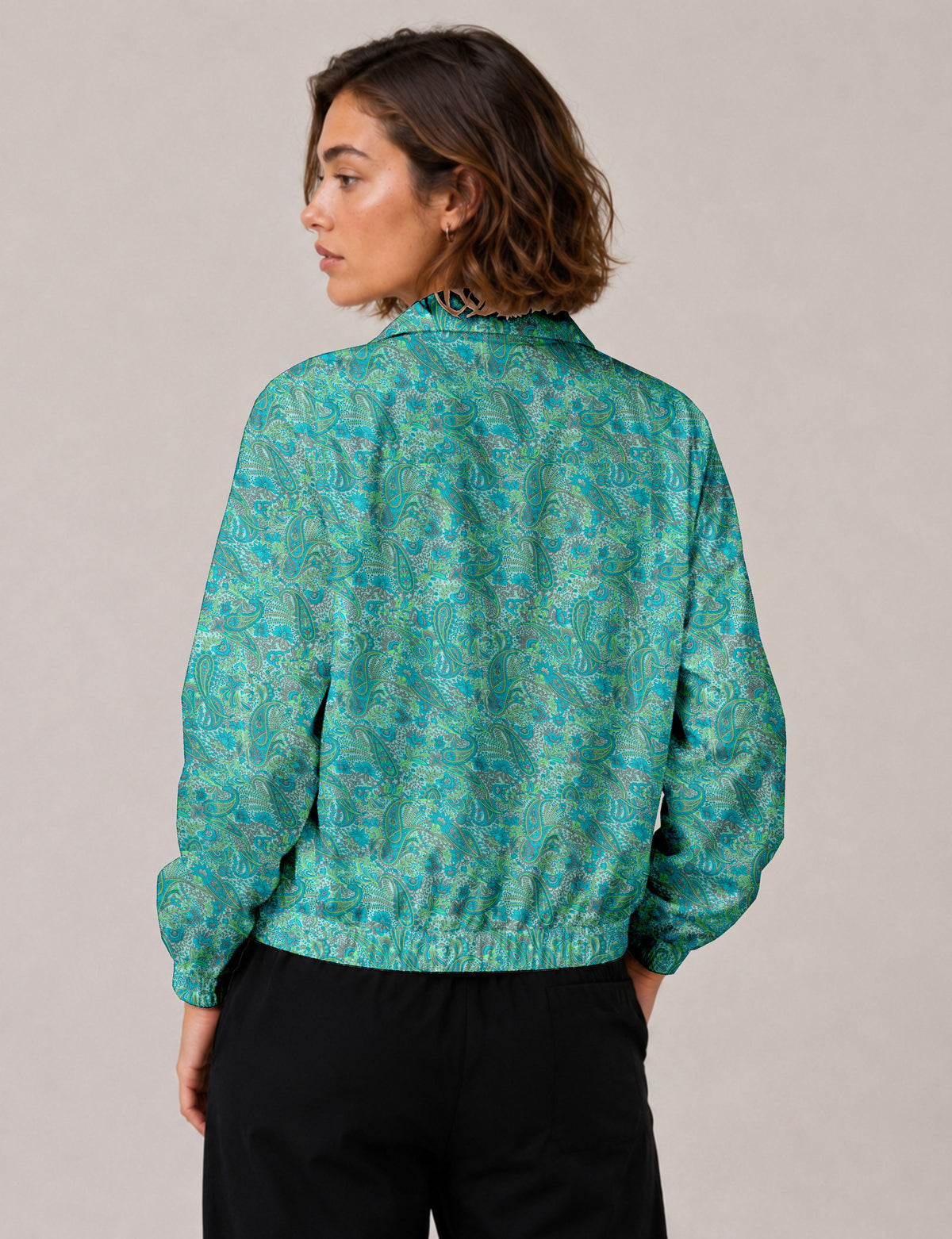 Brown floral bomber jacket with front zipper, elastic cuffs and hem, hanging on white hanger, red floral inner lining visible