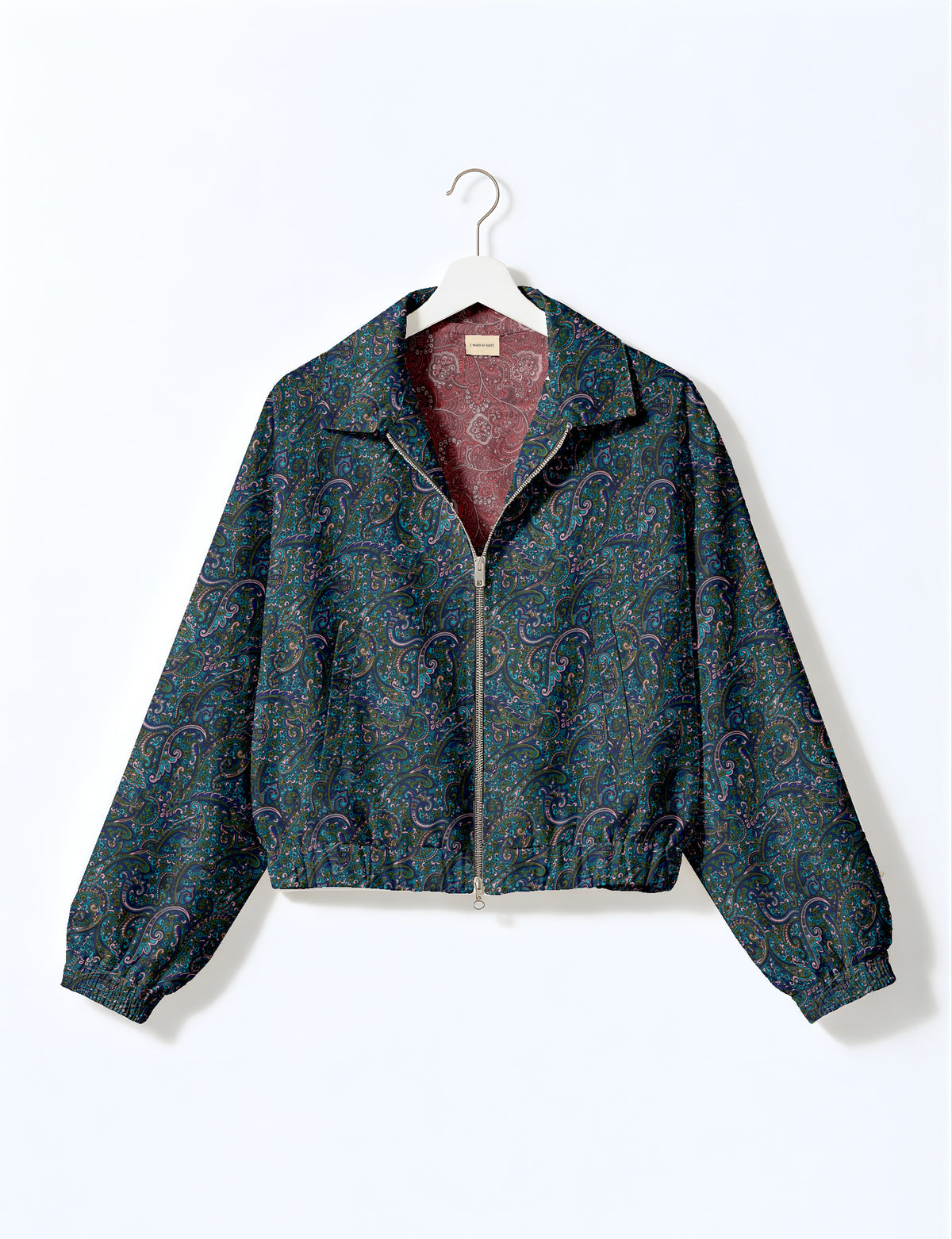 Brown floral bomber jacket with front zipper, elastic cuffs and hem, hanging on white hanger, red floral inner lining visible