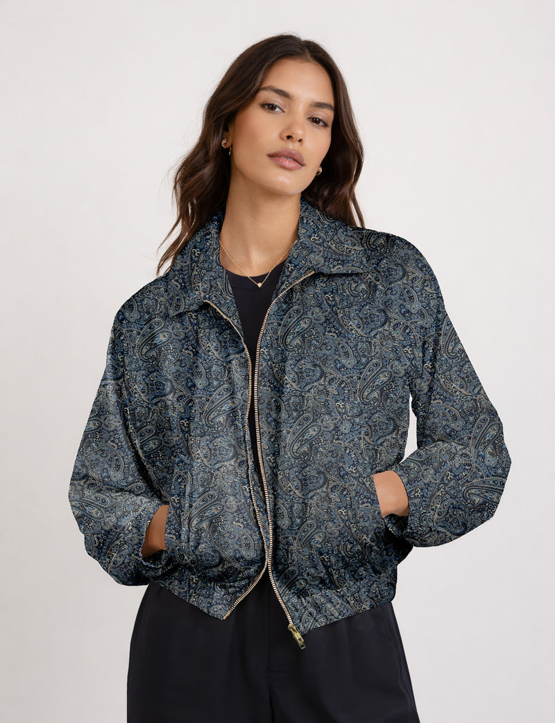 Brown floral bomber jacket with front zipper, elastic cuffs and hem, hanging on white hanger, red floral inner lining visible
