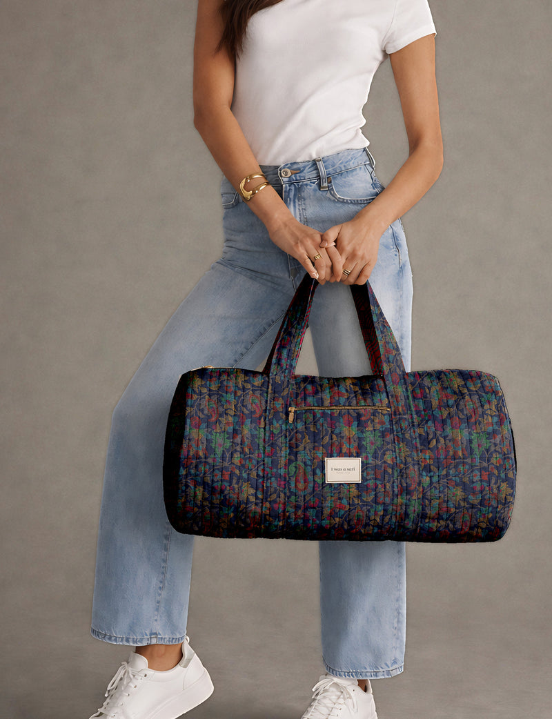 Brown paisley quilted bowling bag with dual handles, front zipper pocket, and "I was a sari" label on front side