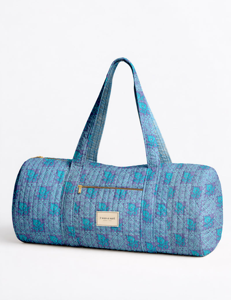 Brown paisley quilted bowling bag with dual handles, front zipper pocket, and "I was a sari" label on front side