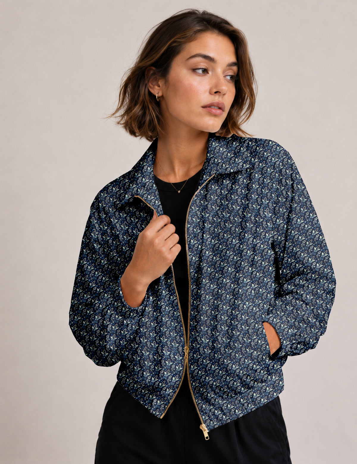 Woman wearing a yellow floral bomber jacket with front zipper, elastic cuffs, and side pockets, shown from front view