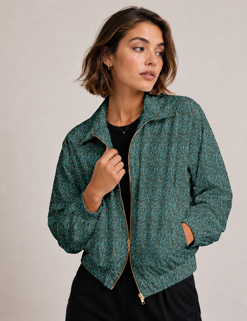 Woman wearing a yellow floral bomber jacket with front zipper, elastic cuffs, and side pockets, shown from front view