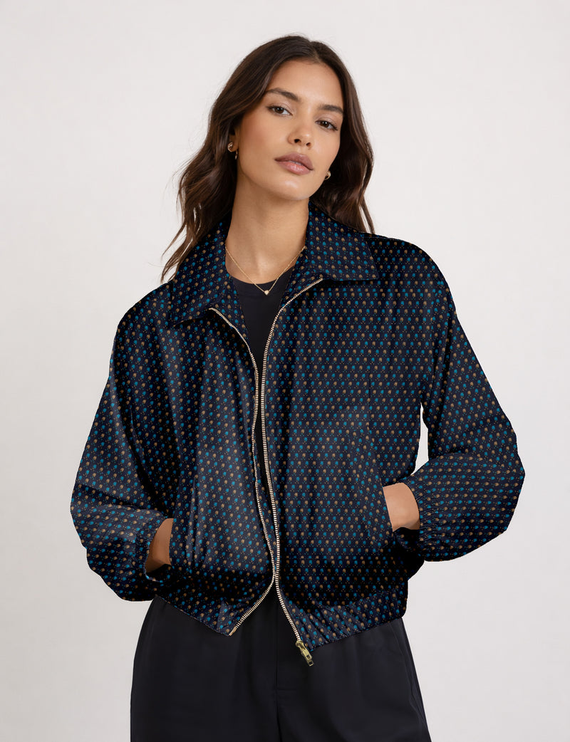 Brown floral bomber jacket with front zipper, elastic cuffs and hem, hanging on white hanger, red floral inner lining visible