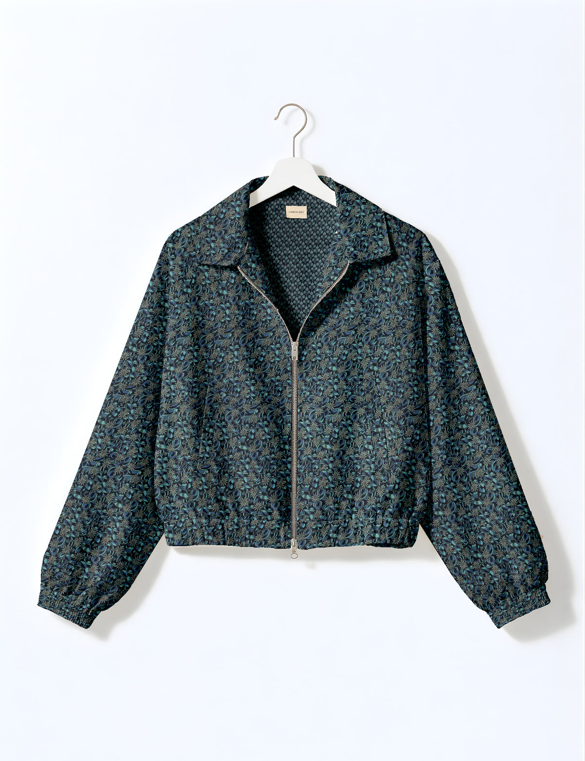Brown floral bomber jacket with front zipper, elastic cuffs and hem, hanging on white hanger, red floral inner lining visible
