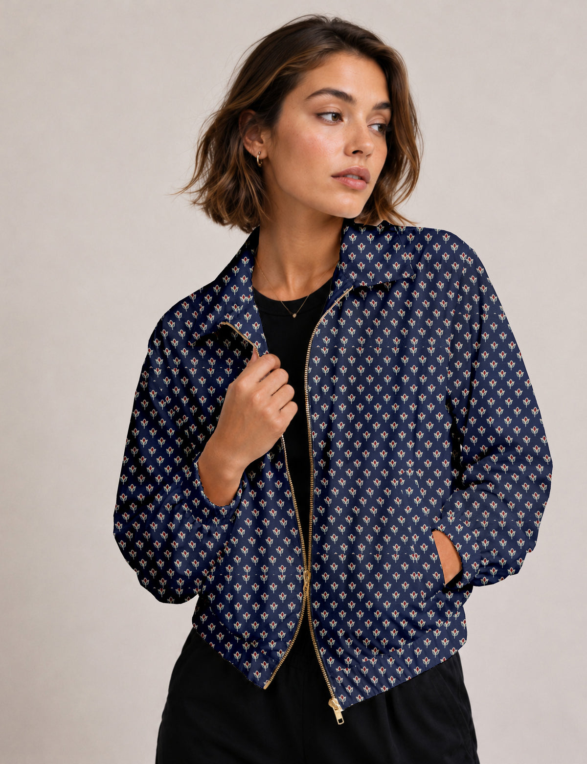Woman wearing a yellow floral bomber jacket with front zipper, elastic cuffs, and side pockets, shown from front view