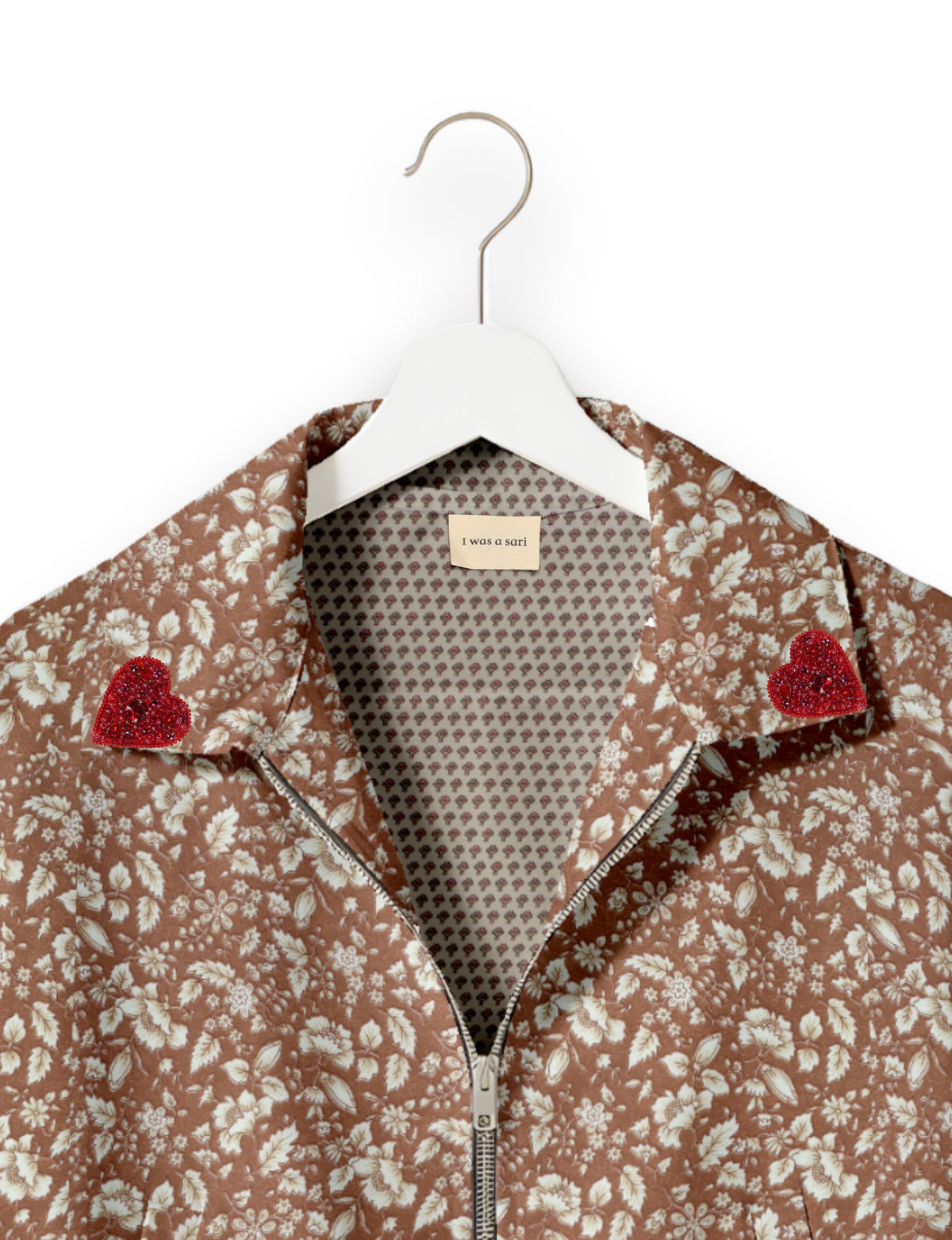 Brown floral bomber jacket with silver zipper, red beaded heart patches on collar, and "I was a sari" label inside collar